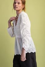 Load image into Gallery viewer, Woman wearing a white blouse with lace details on a light green background