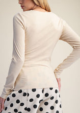 Load image into Gallery viewer, Woman wearing a beige long-sleeve top and polka dot pants on a plain background
