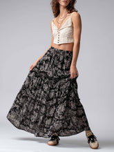 Load image into Gallery viewer, Woman wearing a cream top and black patterned skirt on a gray background