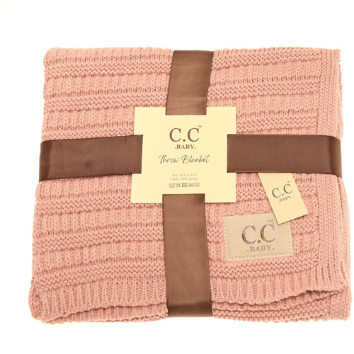 Pink knitted blanket with brown ribbons and C.C Baby tags on a white background