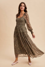 Load image into Gallery viewer, Woman wearing a long, patterned dress on a beige background