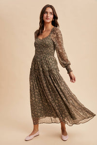 Woman wearing a long, patterned dress on a beige background