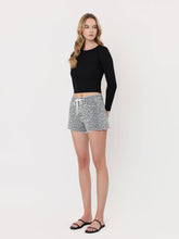 Load image into Gallery viewer, Woman wearing a black long-sleeve top and gray patterned shorts on a white background