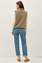 Load image into Gallery viewer, Person wearing a beige sweater vest over a white shirt with blue jeans on a plain background