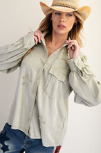 Load image into Gallery viewer, Woman wearing a light green shirt with star patterns, blue jeans, and a beige hat on a plain background