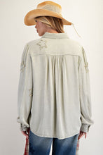 Load image into Gallery viewer, Person wearing a light-colored denim jacket with star details and a straw hat on a white background