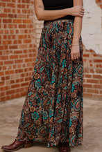 Load image into Gallery viewer, Person wearing a patterned skirt with a brick wall background