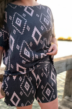 Load image into Gallery viewer, Person wearing a navy blue and white patterned outfit by a waterfront.