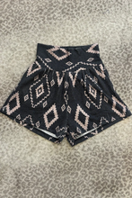 Load image into Gallery viewer, Black and white patterned shorts on a textured surface